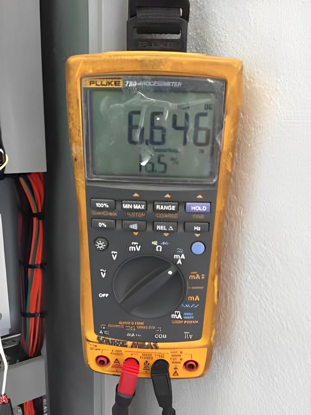 Close-up of a digital multimeter displaying a voltage reading during testing.
